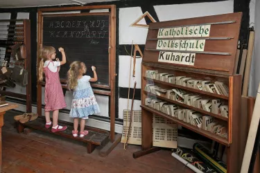 Zwei kleine Mädchen schreiben an die Tafel im Schulsaal