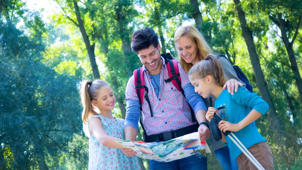 Familie beim Wandern schaut in Wanderkarte