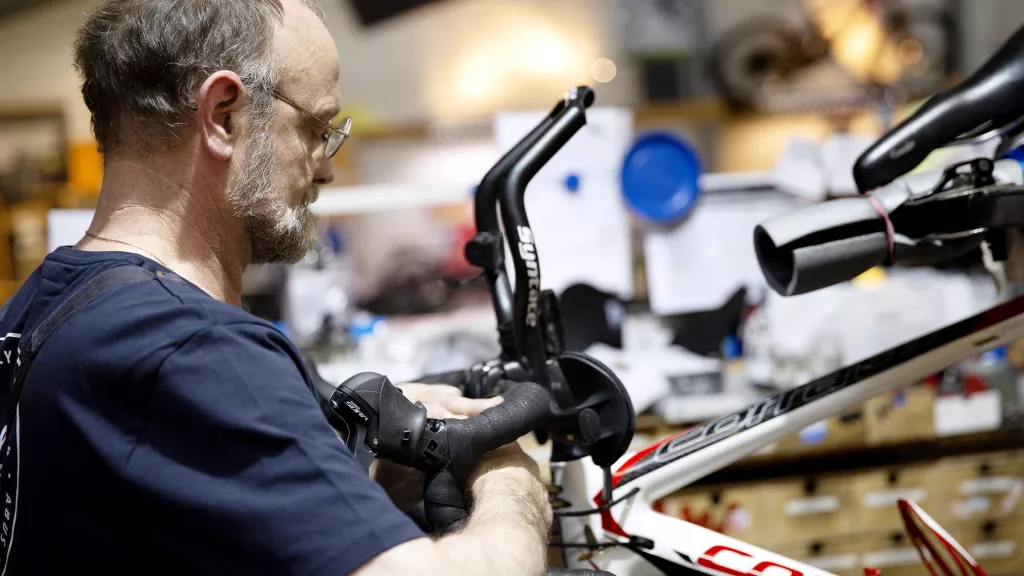 Fahrradwerkstatt - Handwerker bei der Reparatur eines Fahrrades
