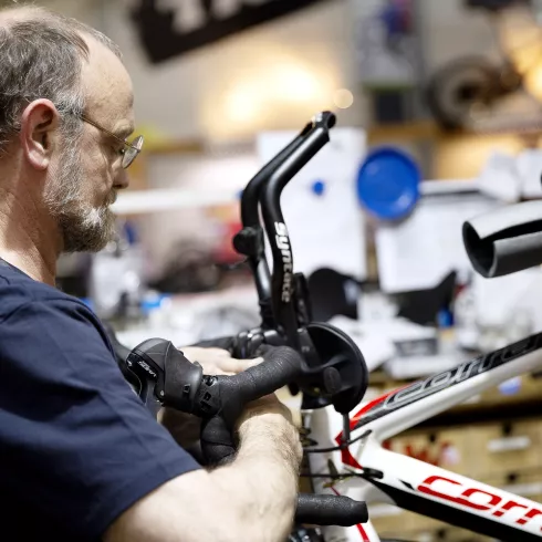 Fahrradwerkstatt - Handwerker bei der Reparatur eines Fahrrades